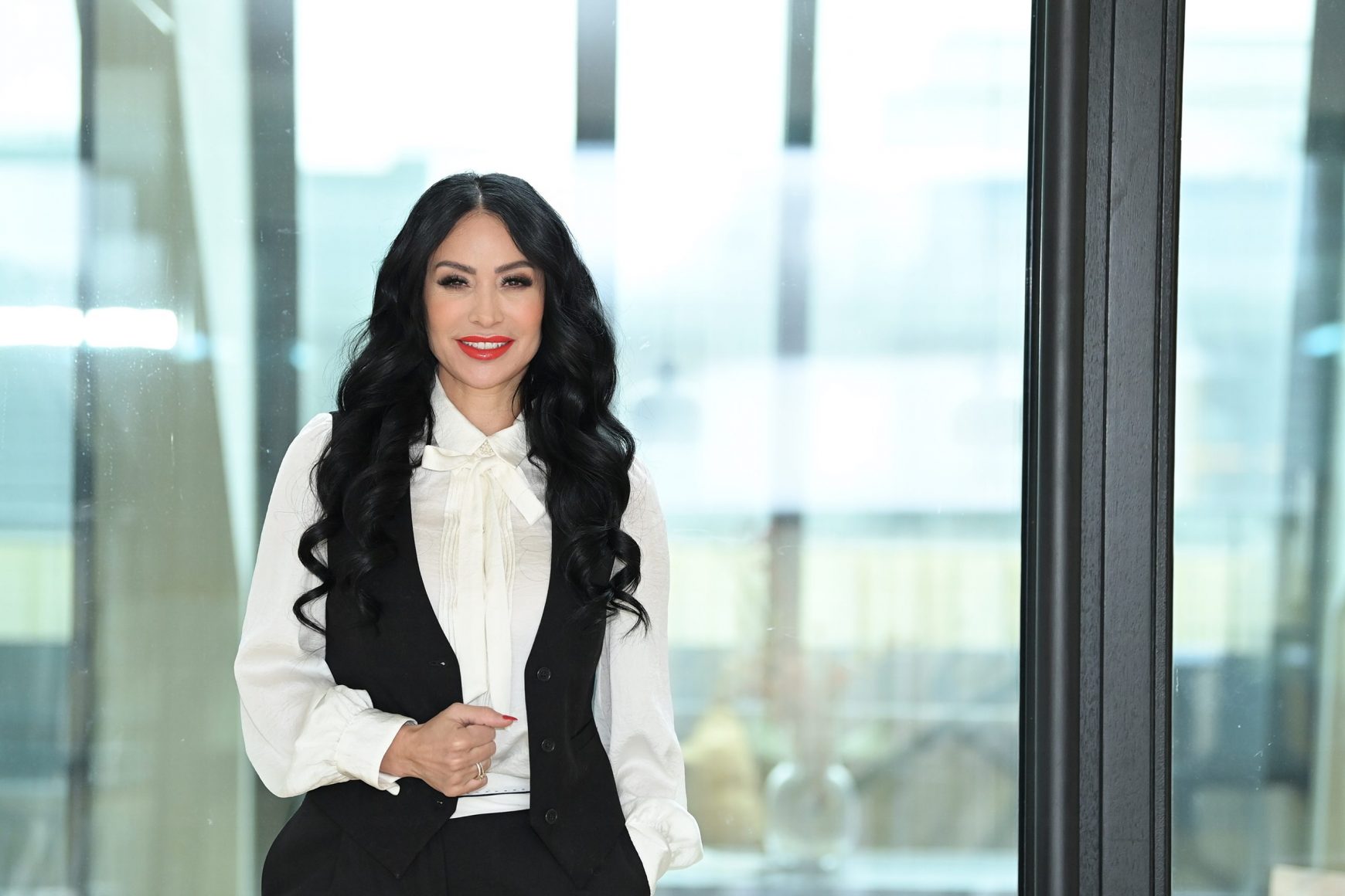 High Level Business Mentorin Gönül Pehlivan vor einer Glaswand mit Zweiteiler über 5 Wege, um dein Coaching-Business zu skalieren